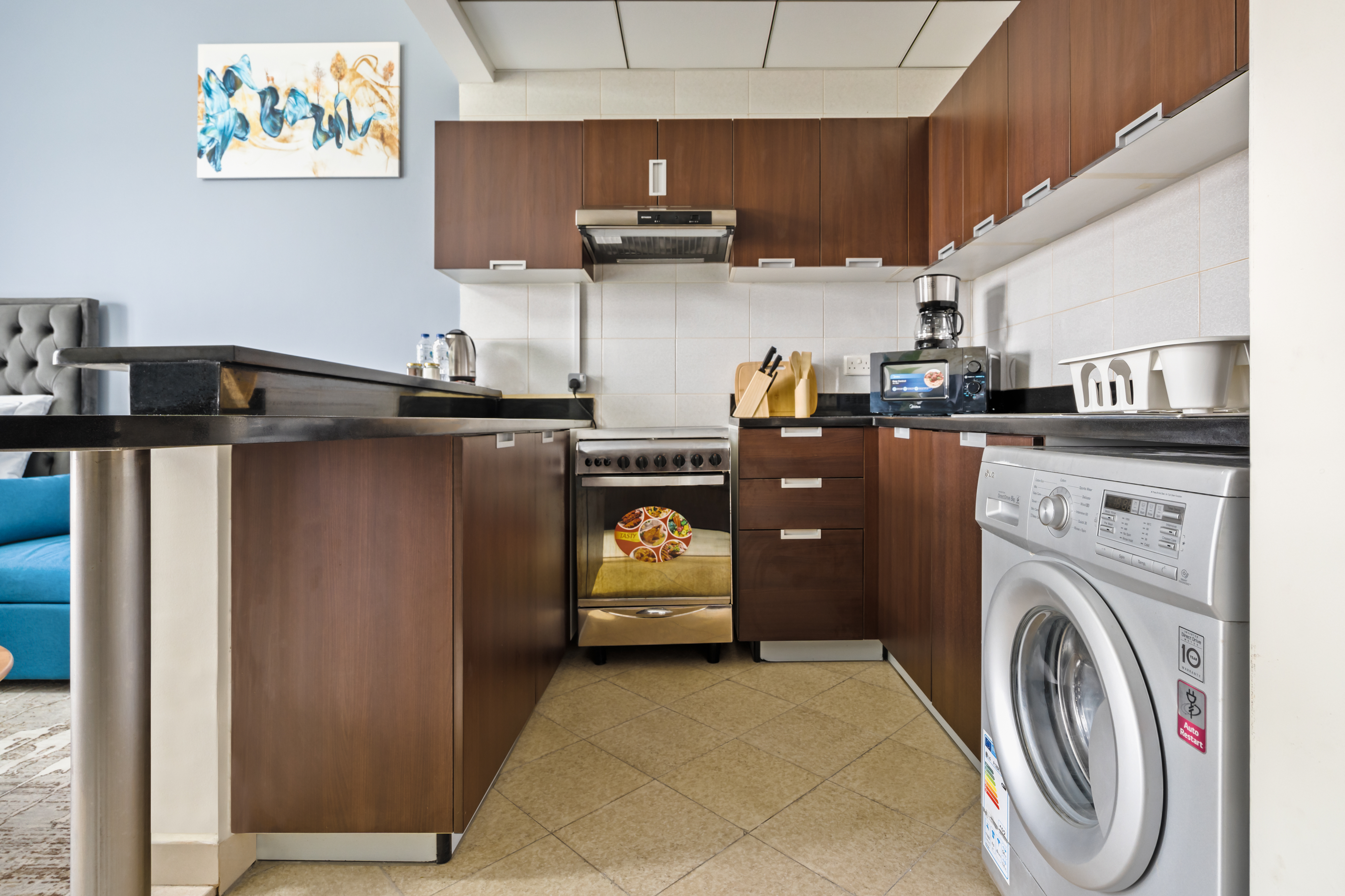 This modern apartment features a sleek and functional kitchen with clean lines, wooden cabinetry, and creating a bright and practical space for the discerning resident.
