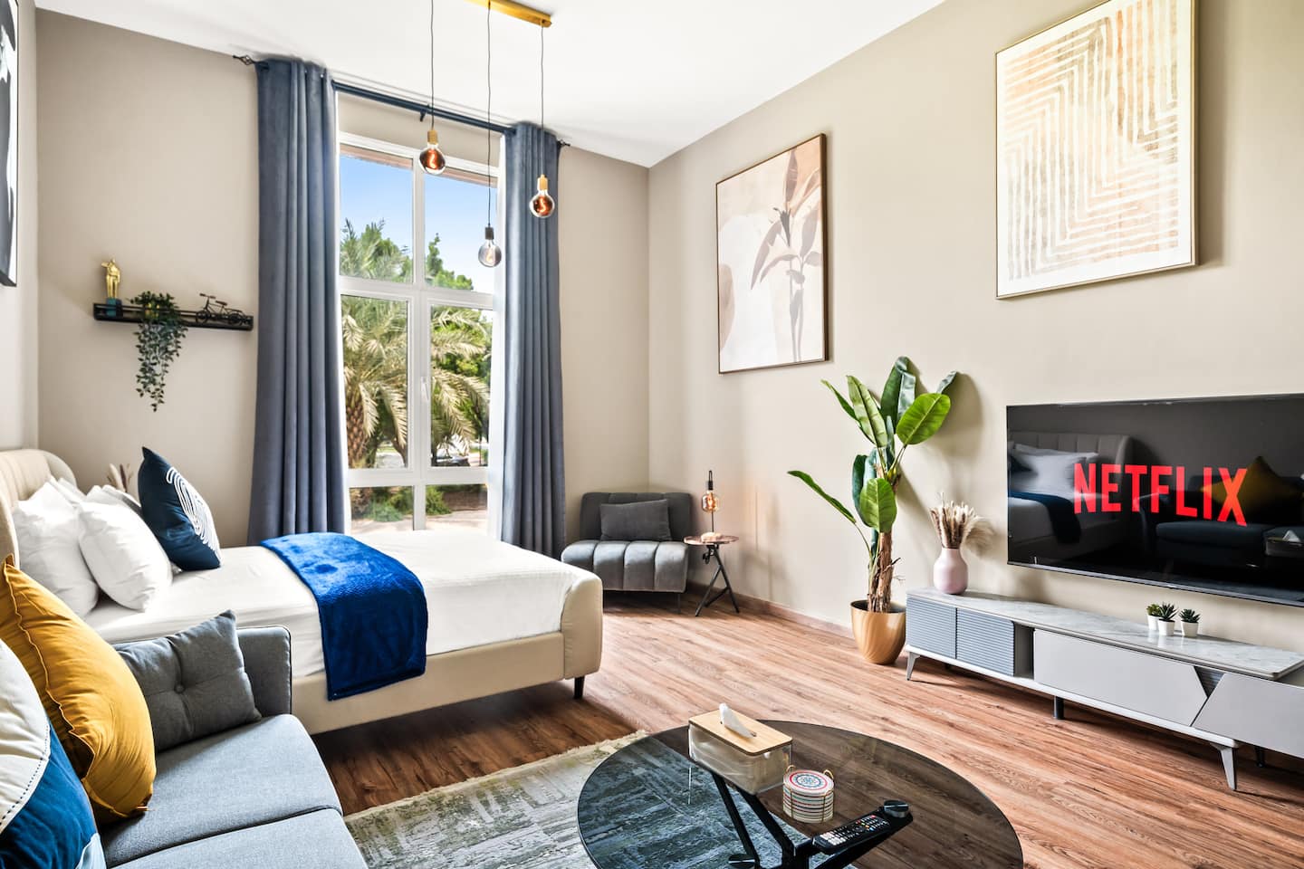 This modern living space features a large window showcasing a stunning garden view, complemented by contemporary and industrial design elements.
