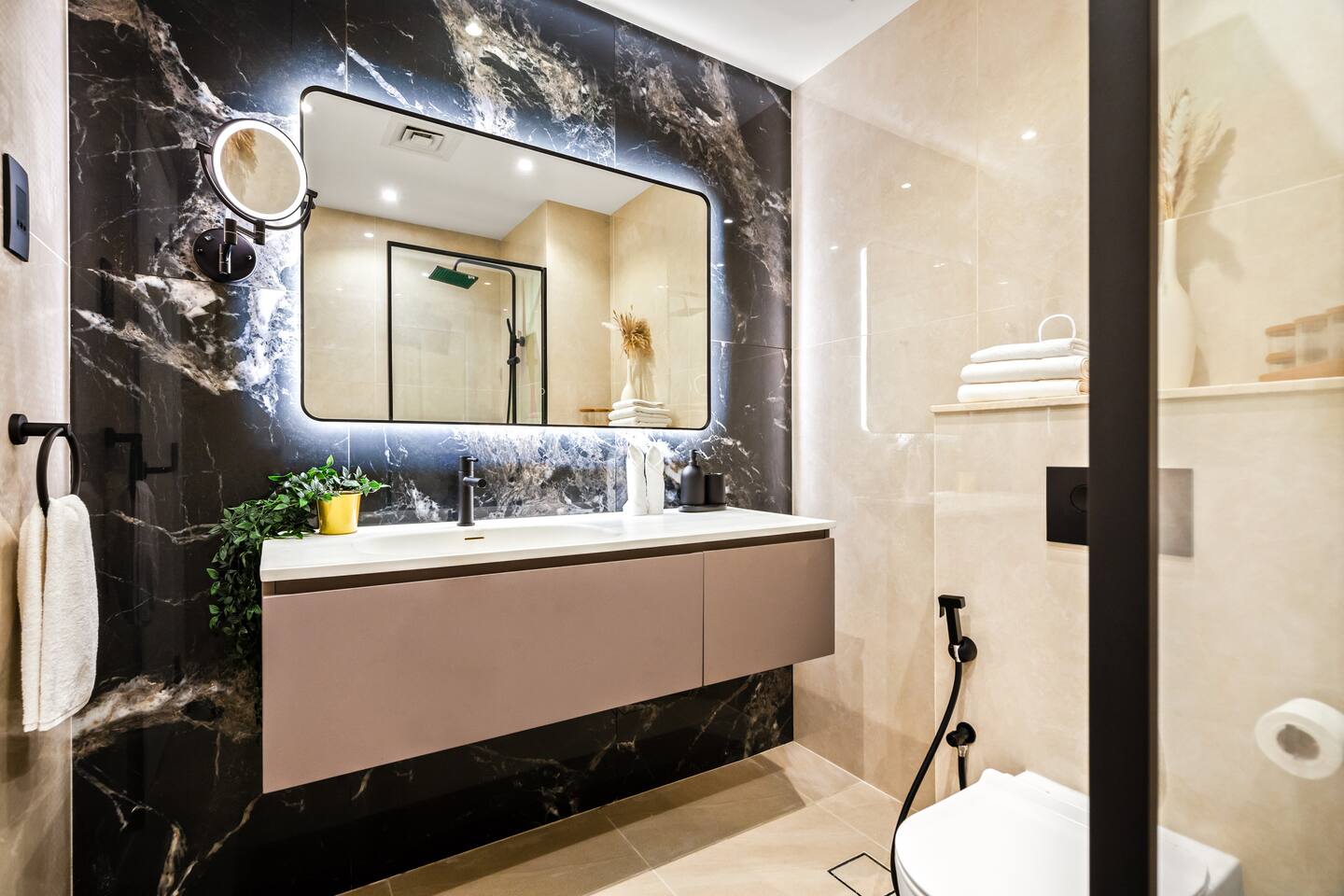 This modern bathroom exudes a serene and sophisticated ambiance, with a neutral color palette, clean lines, and high-end fixtures that create a harmonious and visually pleasing space, enhanced by the marble-like countertop and vessel sink.